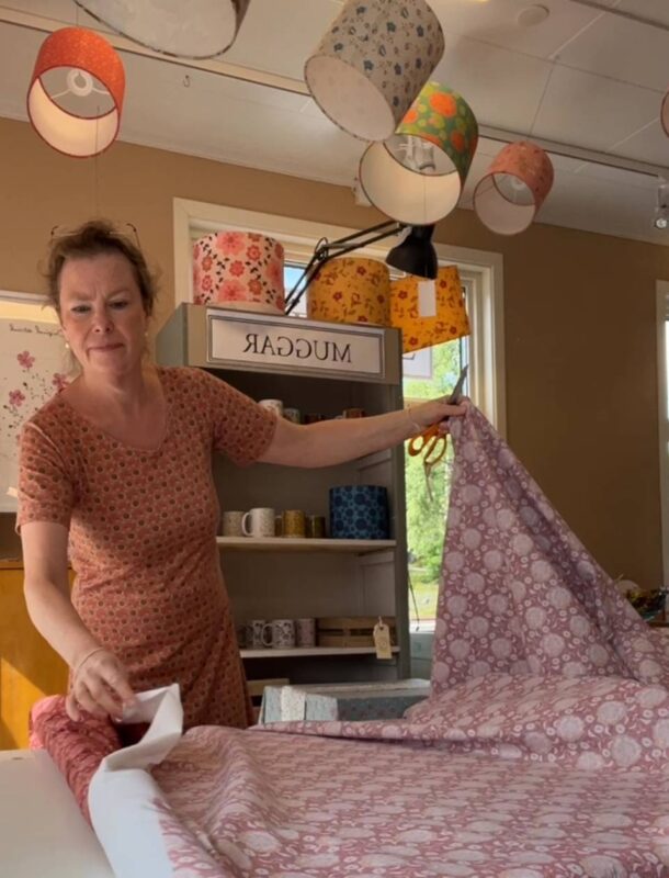 Annette cutting printed fabric at her boutique