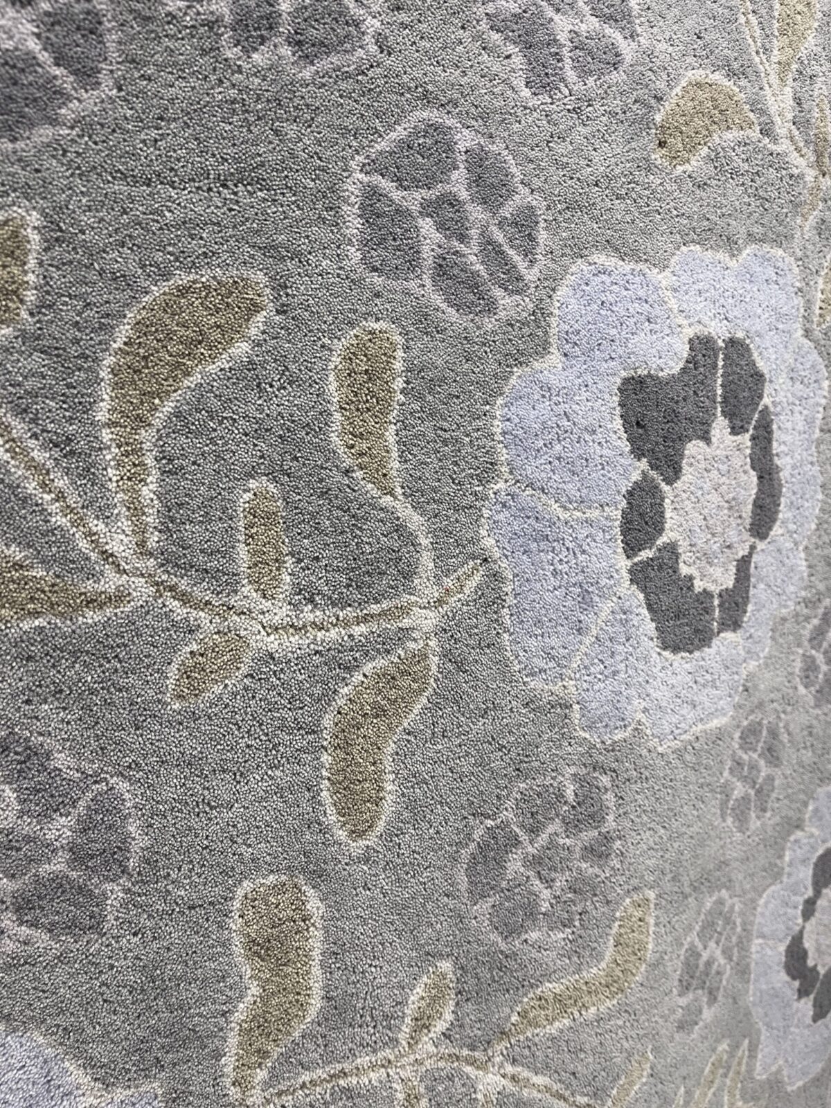 Detalj av ljust grågrön ullmatta